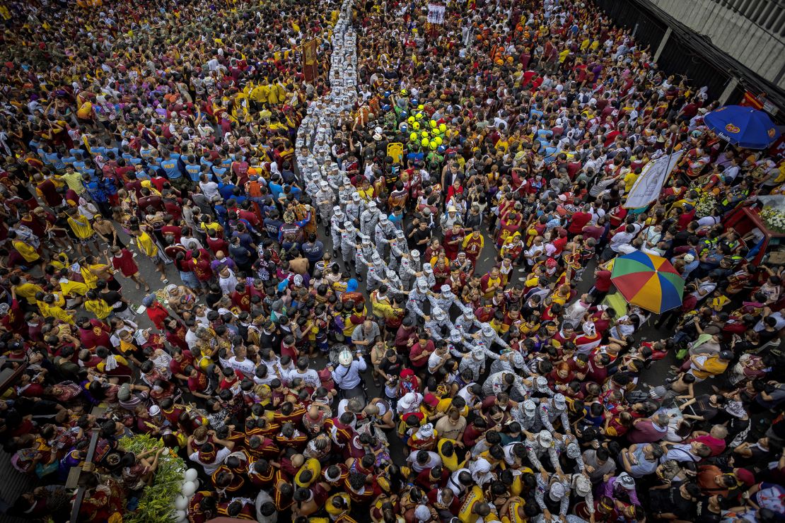 Coast Guard troops form a line ‍as they guard the procession of the Black​ Nazarene in Manila.