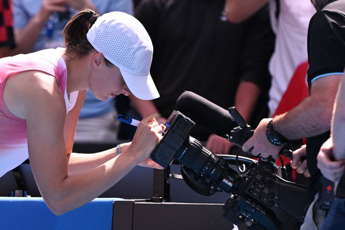 Poland's Iga Świątek writes a message on a broadcast camera following her victory at the Australian Open.