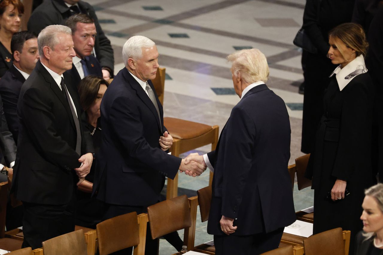 Former Vice President Mike Pence and President-elect Donald Trump shake hands as Trump arrives at the funeral of former President Jimmy Carter in Washington, DC, on January 9.