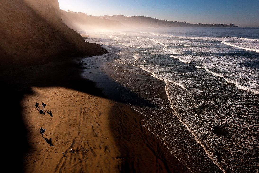 An aerial view of surfers as they walk along Black's Beach, north of San Diego.