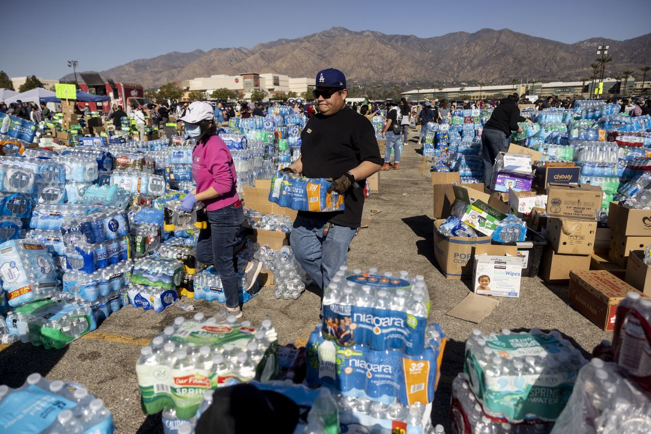 Voluntarios llevan agua para los evacuados del incendio de Eaton en un centro de donaciones en Santa Anita Park, Arcadia, California, el lunes.