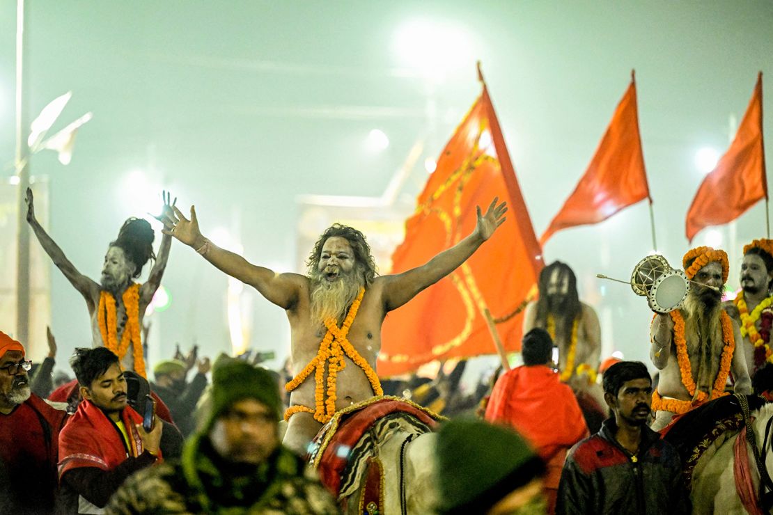 Ash-smeared Naga Sadhus or Hindu holy men arrive to take a dip in Sangam to mark the Maha Kumbh Mela festival, in Prayagraj on January 14, 2025.