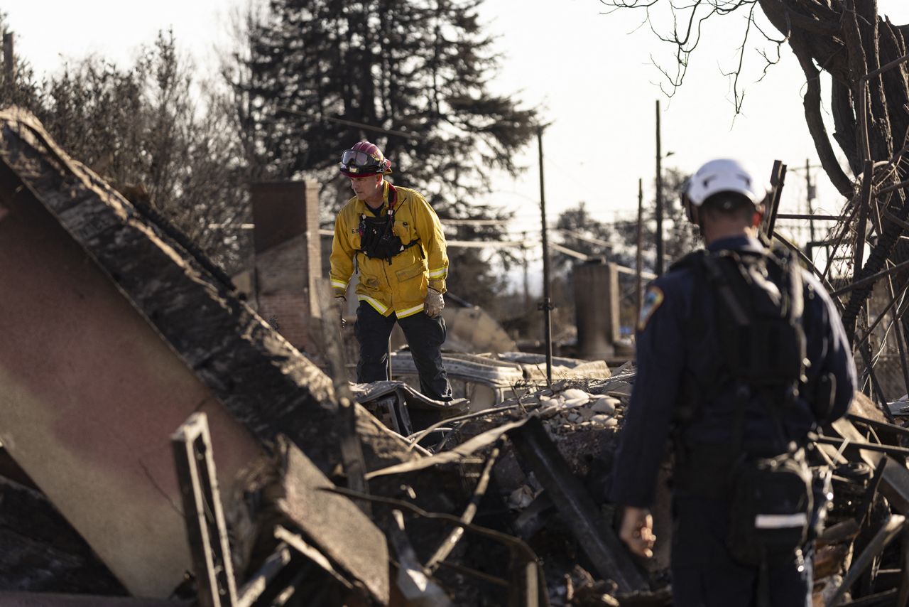 A firefighter with the urban rescue team looks through the remains of a house reduced to rubble by the Eaton fire during search and rescue operations in Altadena, California, on Monday.