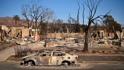 A burnt car sits outside a destroyed home amid the rubble of the fire-ravaged Pacific Palisades Bowl Mobile Estates in Los Angeles, California, on January 13, 2025. Firefighters were battling massive wildfires on January 13 that have ravaged Los Angeles and killed at least 24 people, with officials warning of incoming dangerous winds that could whip up the blazes further. (Photo by AGUSTIN PAULLIER / AFP) (Photo by AGUSTIN PAULLIER/AFP via Getty Images)