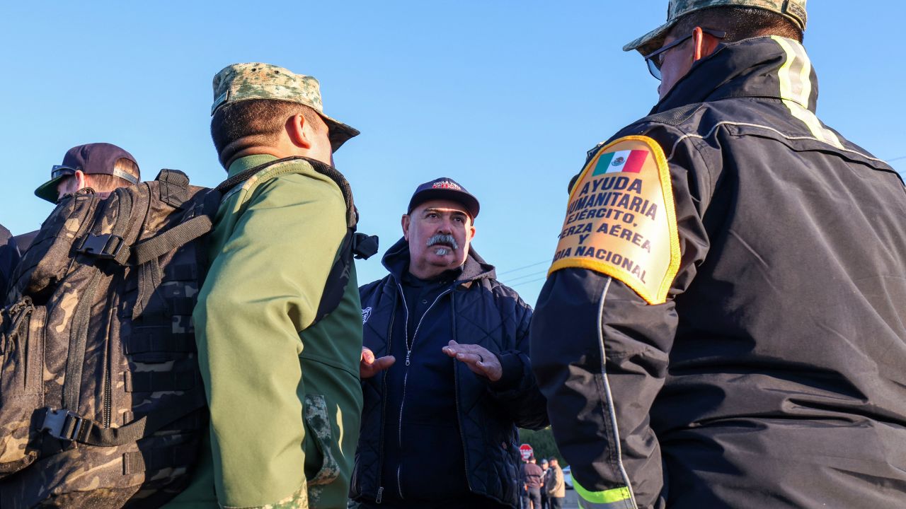 Members of the Mexican firefighter force have a meeting with their colleagues from Cal Fire at the first responders base camp set up at Zuma Beach, on January 13, 2025, in Malibu, California. A huge village has sprung up on the golden sands of a Malibu beach, temporary home to thousands of firefighters from all over North America, where the brave men and women battling Los Angeles' fires eat, sleep and recuperate. Around 5,000 first responders mingle among trailers and tents, served calorie-laden breakfasts by inmates drafted in to help in the enormous effort. (Photo by VALERIE MACON / AFP) (Photo by VALERIE MACON/AFP via Getty Images)