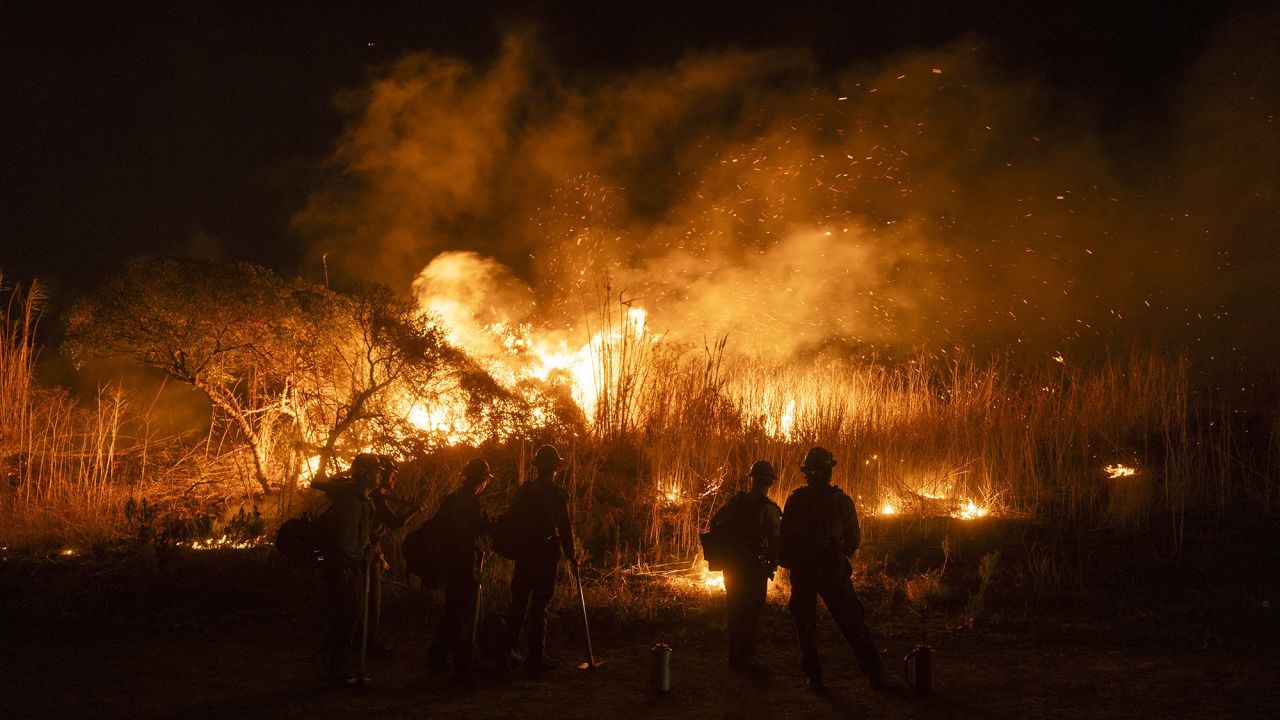Firefighters monitor and control the spread of the Auto Fire in Oxnard, North West of Los Angeles, California, on January 13, 2025. US officials warned "dangerous and strong" winds were set to push deadly wildfires further through Los Angeles residential areas January 12 as firefighters struggled to make progress against the flames. At least 24 people have been confirmed dead from blazes that have ripped through the city, reducing whole neighborhoods to ashes and leaving thousands without homes. (Photo by ETIENNE LAURENT / AFP) (Photo by ETIENNE LAURENT/AFP via Getty Images)