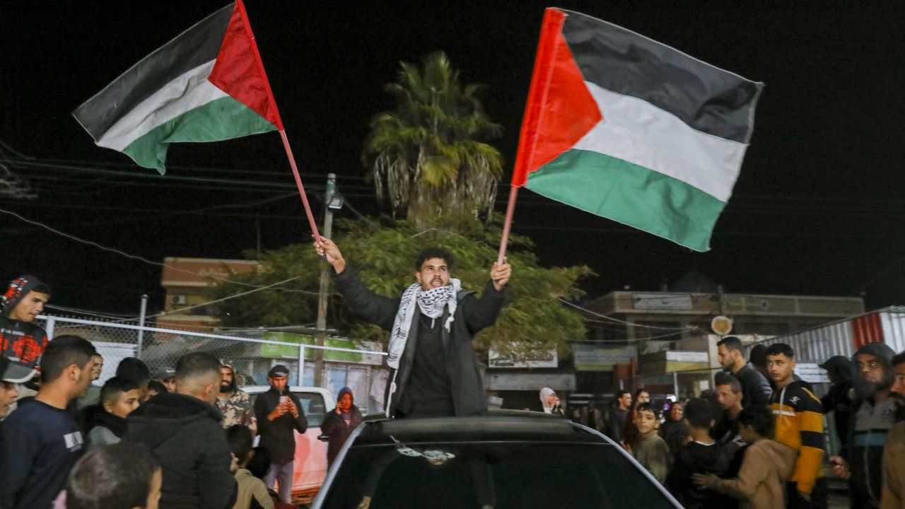 People celebrate along a street at Deir el-Balah in the central Gaza Strip, on January 15, 2025, amid the ongoing war in the Palestinian territory between Israel and Hamas. Crowds of Gazans chanted and embraced on January 15 as news spread that a ceasefire and hostage release deal had been reached between Israel and Hamas aimed at ending more than 15 months of war in the Palestinian territory. (Photo by Youssef Alzanoun / Middle East Images / Middle East Images via AFP) (Photo by YOUSSEF ALZANOUN/Middle East Images/AFP via Getty Images)