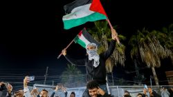 People celebrate along a street at Deir el-Balah in the central Gaza Strip, on January 15, 2025, amid the ongoing war in the Palestinian territory between Israel and Hamas. Crowds of Gazans chanted and embraced on January 15 as news spread that a ceasefire and hostage release deal had been reached between Israel and Hamas aimed at ending more than 15 months of war in the Palestinian territory. (Photo by Youssef Alzanoun / Middle East Images / Middle East Images via AFP) (Photo by YOUSSEF ALZANOUN/Middle East Images/AFP via Getty Images)