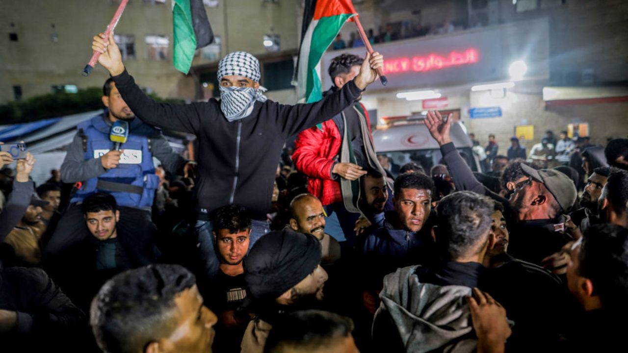 People celebrate along a street at Deir el-Balah in the central Gaza Strip, on January 15, 2025, amid the ongoing war in the Palestinian territory between Israel and Hamas. Crowds of Gazans chanted and embraced on January 15 as news spread that a ceasefire and hostage release deal had been reached between Israel and Hamas aimed at ending more than 15 months of war in the Palestinian territory. (Photo by Saeed Jaras / Middle East Images / Middle East Images via AFP) (Photo by SAEED JARAS/Middle East Images/AFP via Getty Images)