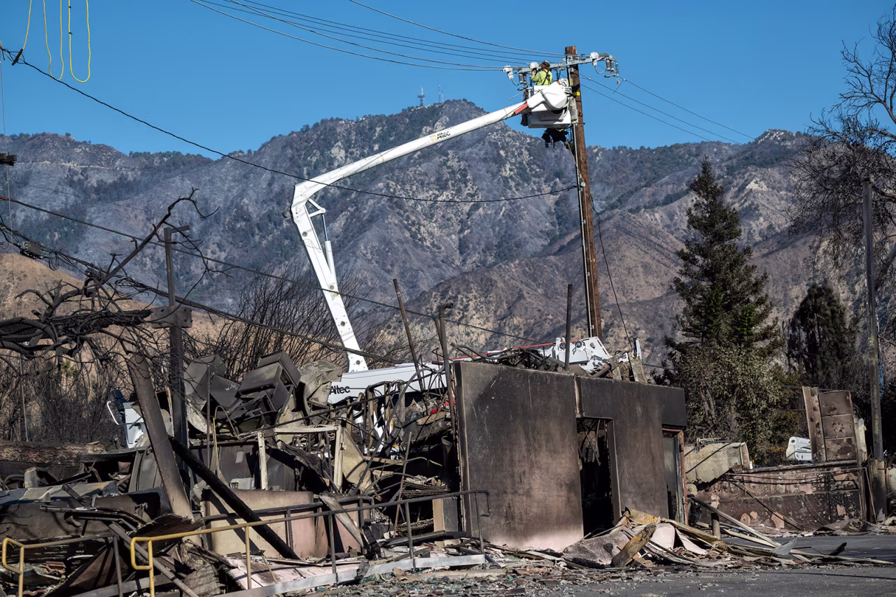 Utilities worker repair lines on Mendocino Ave in the Eaton Fire damaged area on Lake Ave in Altadena, on Tuesday.