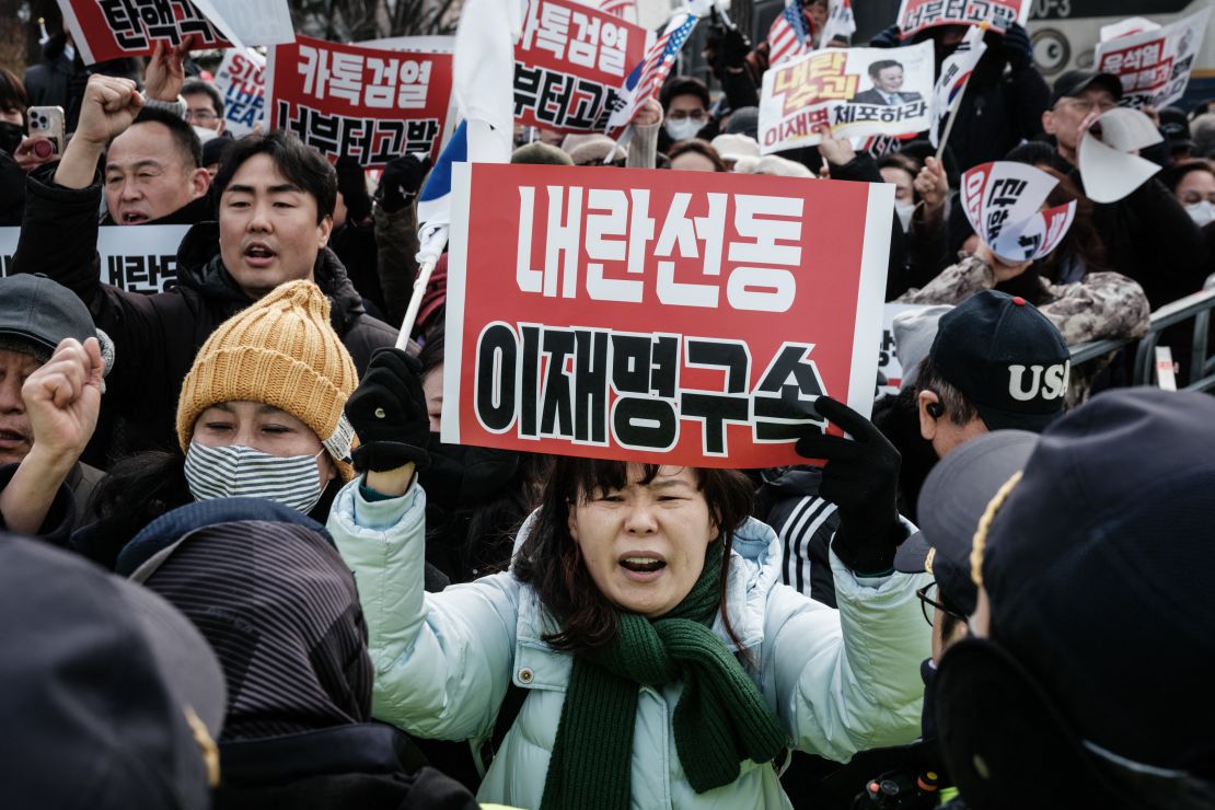 A supporter of detained and impeached South Korean President Yoon Suk Yeol holds a placard that reads "Arrest insurrectionist Lee Jae-myung" during a rally at the entrance of the Seoul Detention Center in Seoul on January 16, 2025.