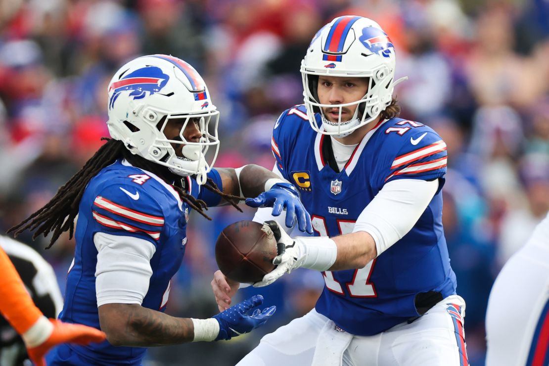 Josh Allen #17 of the Buffalo Bills passes the ball to teammate James Cook #4 in the third quarter against the Denver Broncos during the AFC Wild Card Playoffs at Highmark Stadium on January 12, 2025 in Orchard Park, New York.