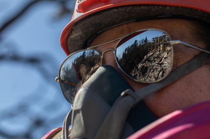 A member of a search-and-rescue team inspects a burned house in the Pacific Palisades neighborhood of Los Angeles on Thursday, January 16.