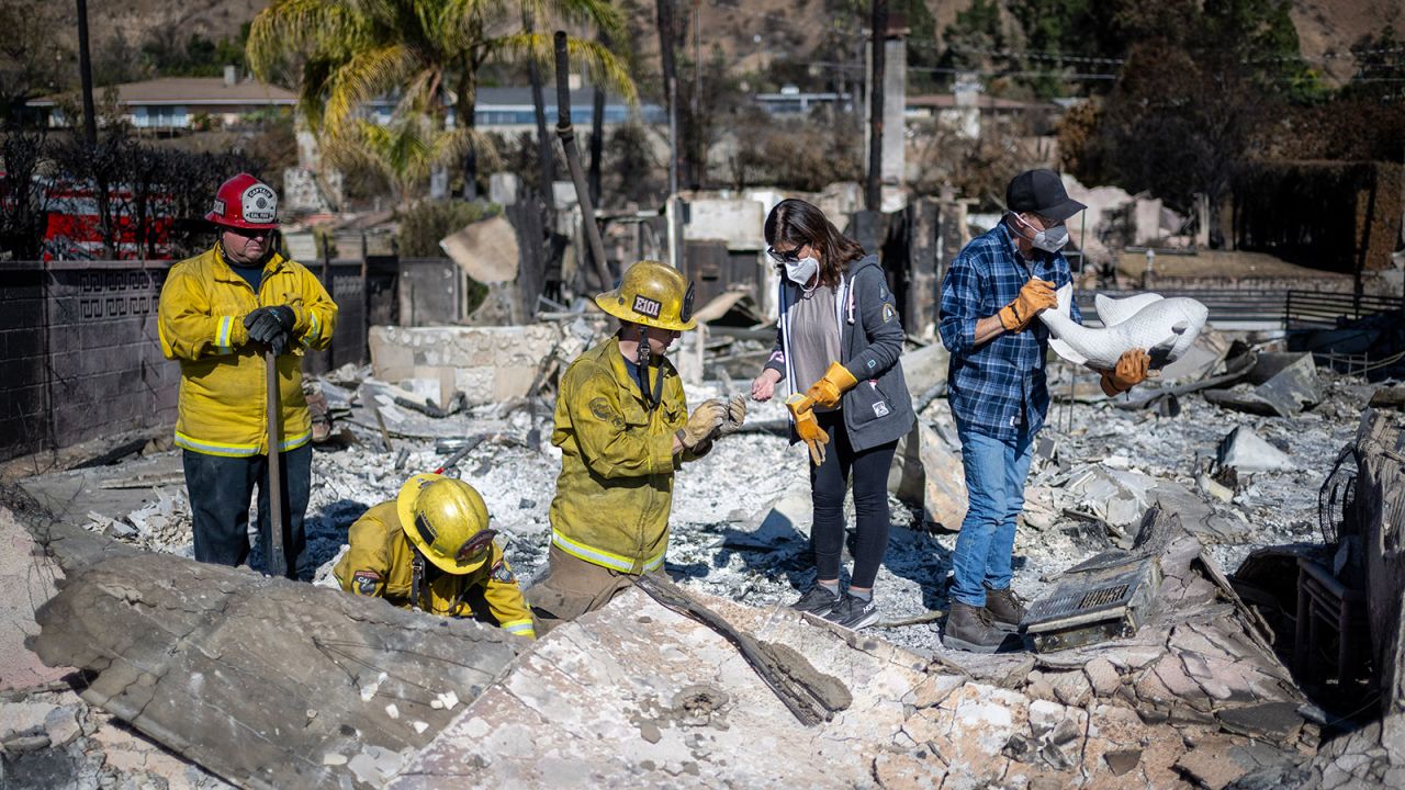 Cal Fire Captain Jeff Crile, Engineer Michael Gonzales and Firefighter Trent Houser, help Darryl and Christine Montes look through the debris of their home for anything of value in Pasadena on Thursday.