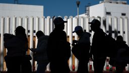 TOPSHOT - Asylum seekers queue before crossing to the US for their asylum appointment at El Chaparral crossing port in Tijuana, Baja California state, Mexico on January 13, 2025. As US President-elect Donald Trump prepares to take office next week with a vow to crack down hard on illegal migration, gangs are using threats and extortion to exploit those trying to arrive in time. (Photo by Guillermo Arias / AFP) (Photo by GUILLERMO ARIAS/AFP via Getty Images)