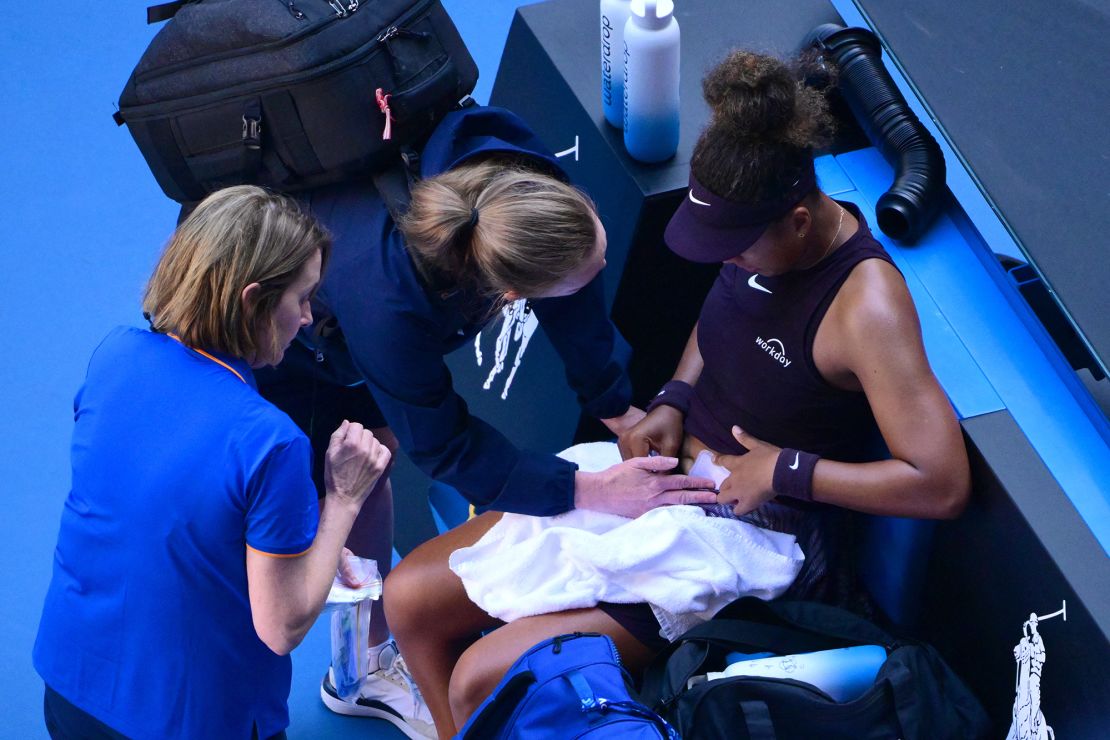 Naomi Osaka receives medical attention during her women's singles match against Switzerland's Belinda Bencic.