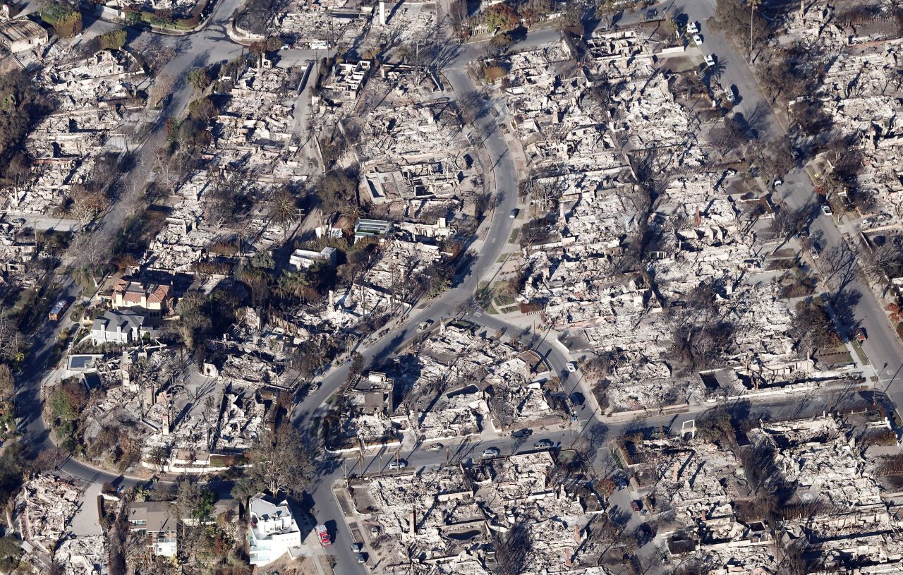 PACIFIC PALISADES, CALIFORNIA - JANUARY 13: An aerial view shows homes destroyed in the Palisades Fire near a few which remain standing as wildfires cause damage and loss through the LA region on January 13, 2025 in Pacific Palisades, California. Multiple wildfires fueled by intense Santa Ana Winds continue to burn across Los Angeles County, with some containment achieved. According to reports, 24 people have died with over 180,000 people under evacuation order or warning. Over 12,000 structures have been destroyed or damaged, while more than 35,000 acres have burned. (Photo by Mario Tama/Getty Images)