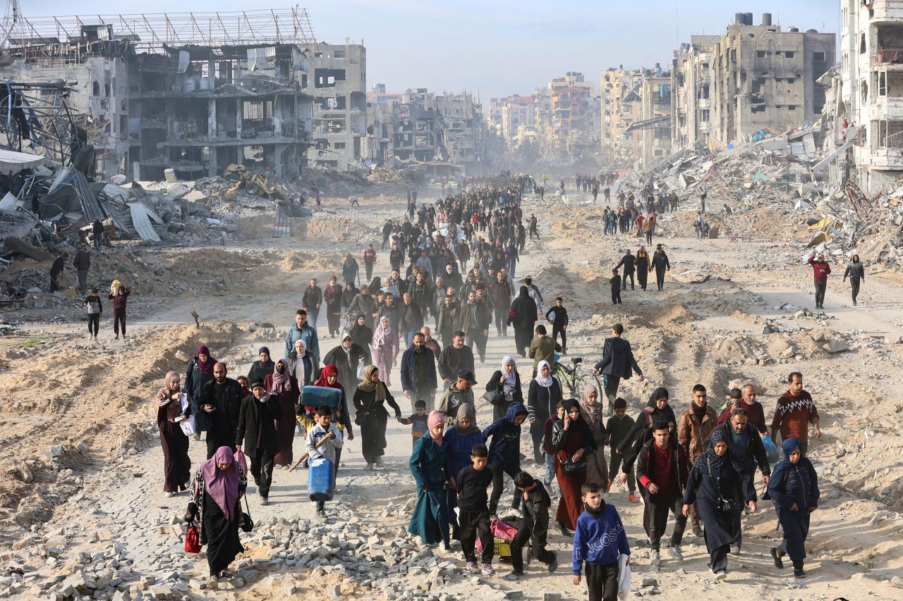 Scores of displaced Palestinians walk along a road in the Saftawi area of Jabalia, as they leave areas near Gaza City where they had taken refuge, toward the further northern part of the Gaza Strip, shortly after a ceasefire deal in the war between Israel and the Palestinian militant group Hamas was expected to be implemented. The long-awaited ceasefire in the Israel-Hamas war was delayed January 19 after Prime Minister Benjamin Netanyahu said at the last minute that it would not take effect until the Palestinian militant group provided a list of the hostages to be released. (Photo by Omar AL-QATTAA / AFP) (Photo by OMAR AL-QATTAA/AFP via Getty Images)