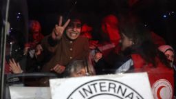 A Palestinian woman flashes the V-sign for victory inside a Red Cross bus carrying some 90 prisoners released by Israel in the early hours of January 20, 2025, upon their arrival in the occupied West Bank town of Beitunia, outside Ramallah. Crowds cheered, chanted and honked car horns as two buses carrying the prisoners arrived in Beitunia following their release as part of the Gaza ceasefire deal that began on January 19 and saw three Israeli hostages freed by Hamas in the Gaza Strip. (Photo by Zain JAAFAR / AFP) (Photo by ZAIN JAAFAR/AFP via Getty Images)