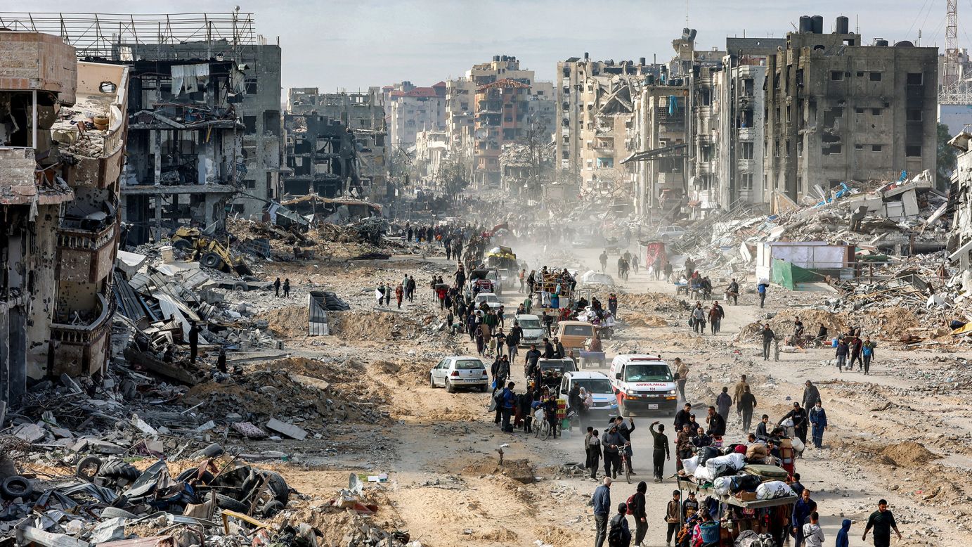 People walk past the rubble of collapsed buildings along Saftawi street in Jabalia in the northern Gaza Strip on January 20, 2025, a day after a short-lived ceasefire went into effect.