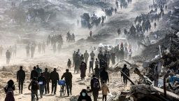 People walk past the rubble of collapsed buildings along Saftawi street in Jabalia in the northern Gaza Strip on January 20, 2025 a day after a ceasefire deal in the war between Israel and Hamas went into effect. (Photo by Omar AL-QATTAA / AFP) (Photo by OMAR AL-QATTAA/AFP via Getty Images)