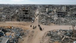 People make their way past the rubble of houses in Rafah on January 20, 2025.