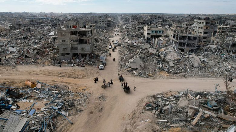 People make their way past the rubble of houses in Rafah on January 20, 2025.