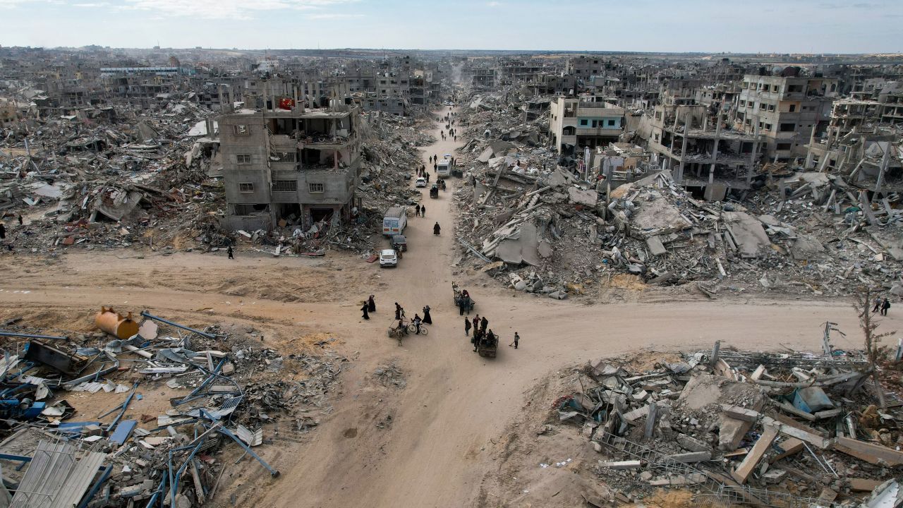 People make their way past the rubble of houses in Rafah on January 20, 2025.