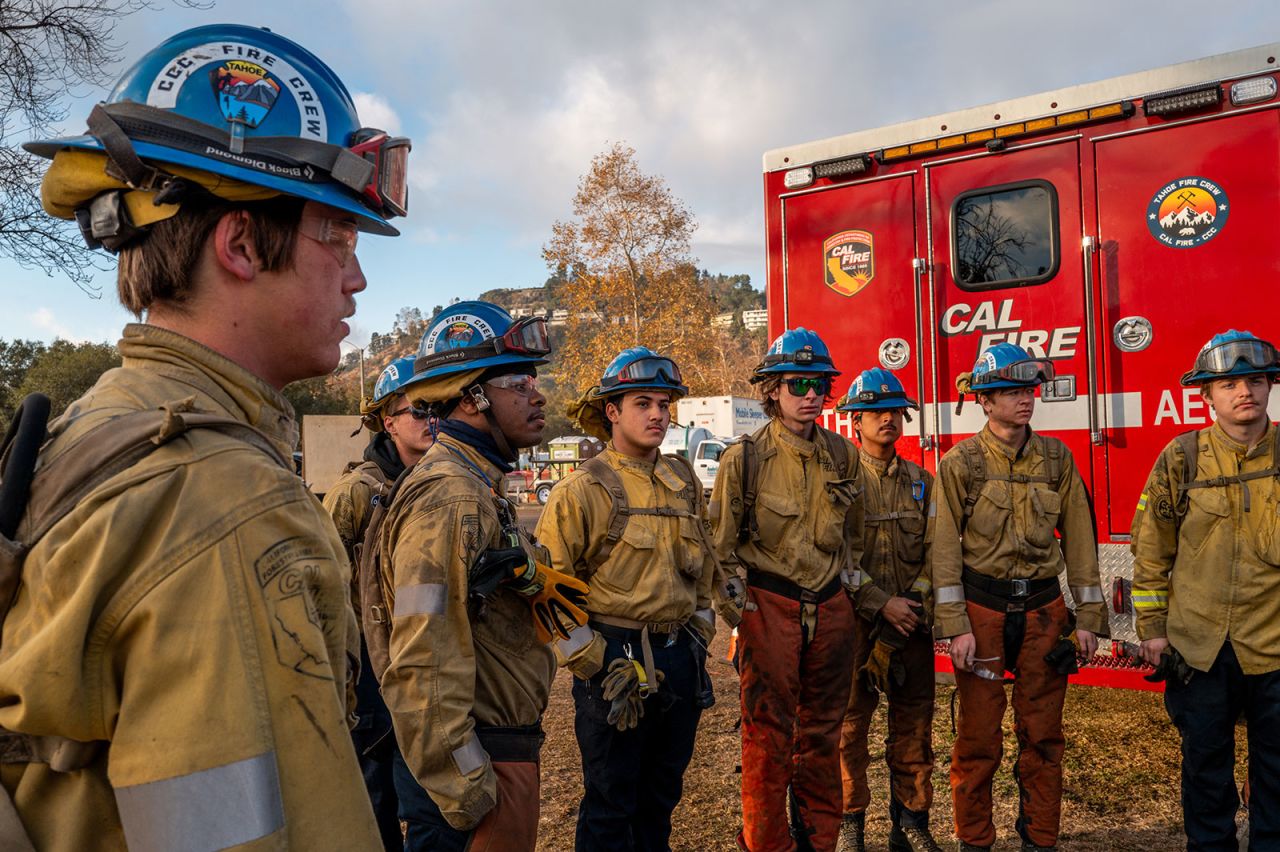 A California Conservation Corps fire crew gathers during a meeting before beginning their shift at the Rose Bowl Stadium on Friday, in Pasadena, California.