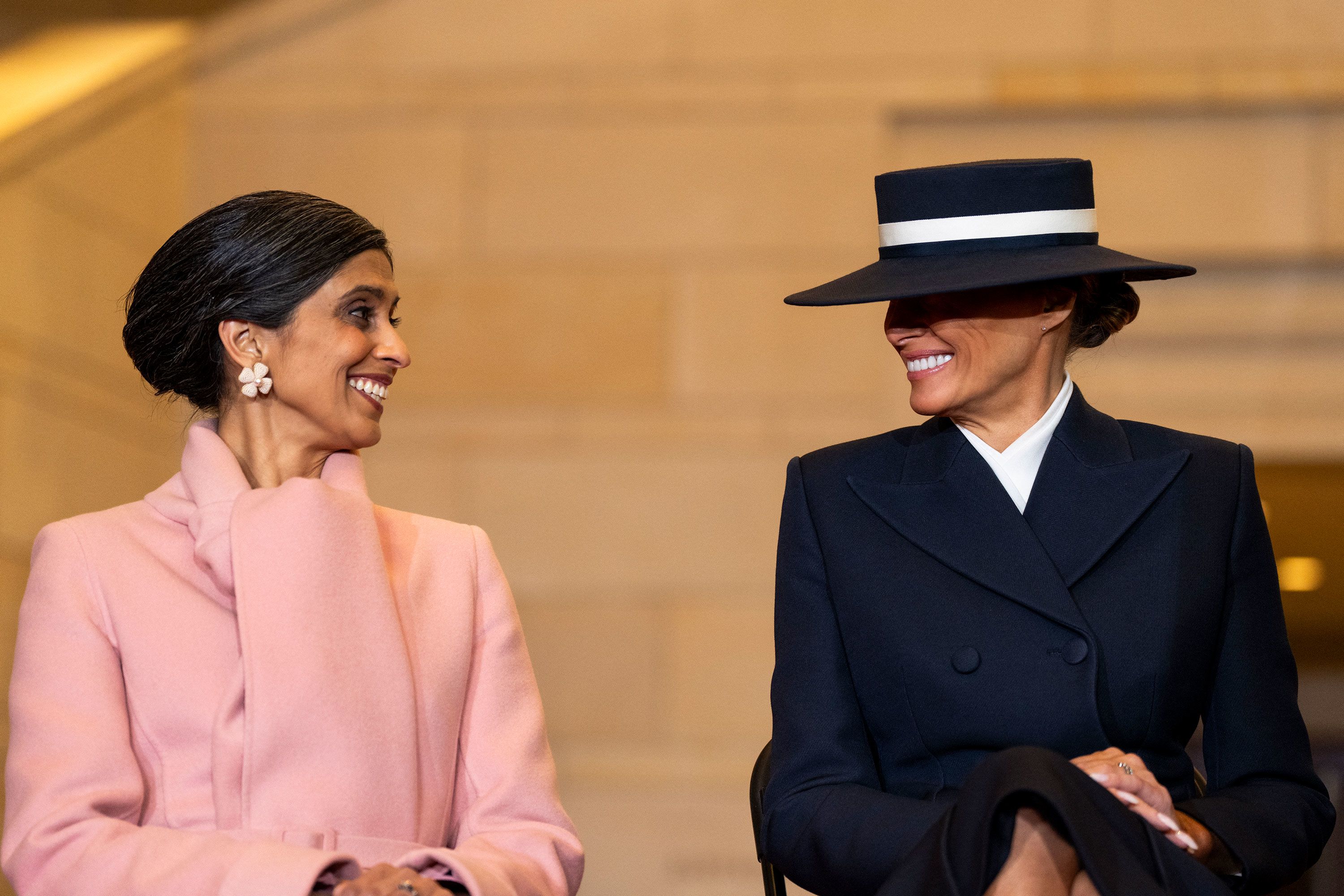 Second lady Usha Vance and first lady Melania Trump smile as President Trump delivers remarks in Emancipation Hall after his inauguration ceremony on Monday.