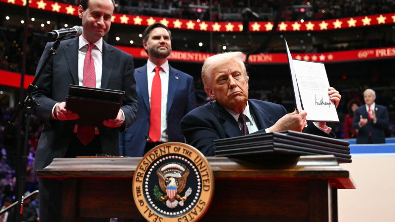 US President Donald Trump holds an executive order he just signed during the inaugural parade inside Capital One Arena, in Washington, DC, on January 20, 2025. (Photo by Jim WATSON / AFP) (Photo by JIM WATSON/AFP via Getty Images)