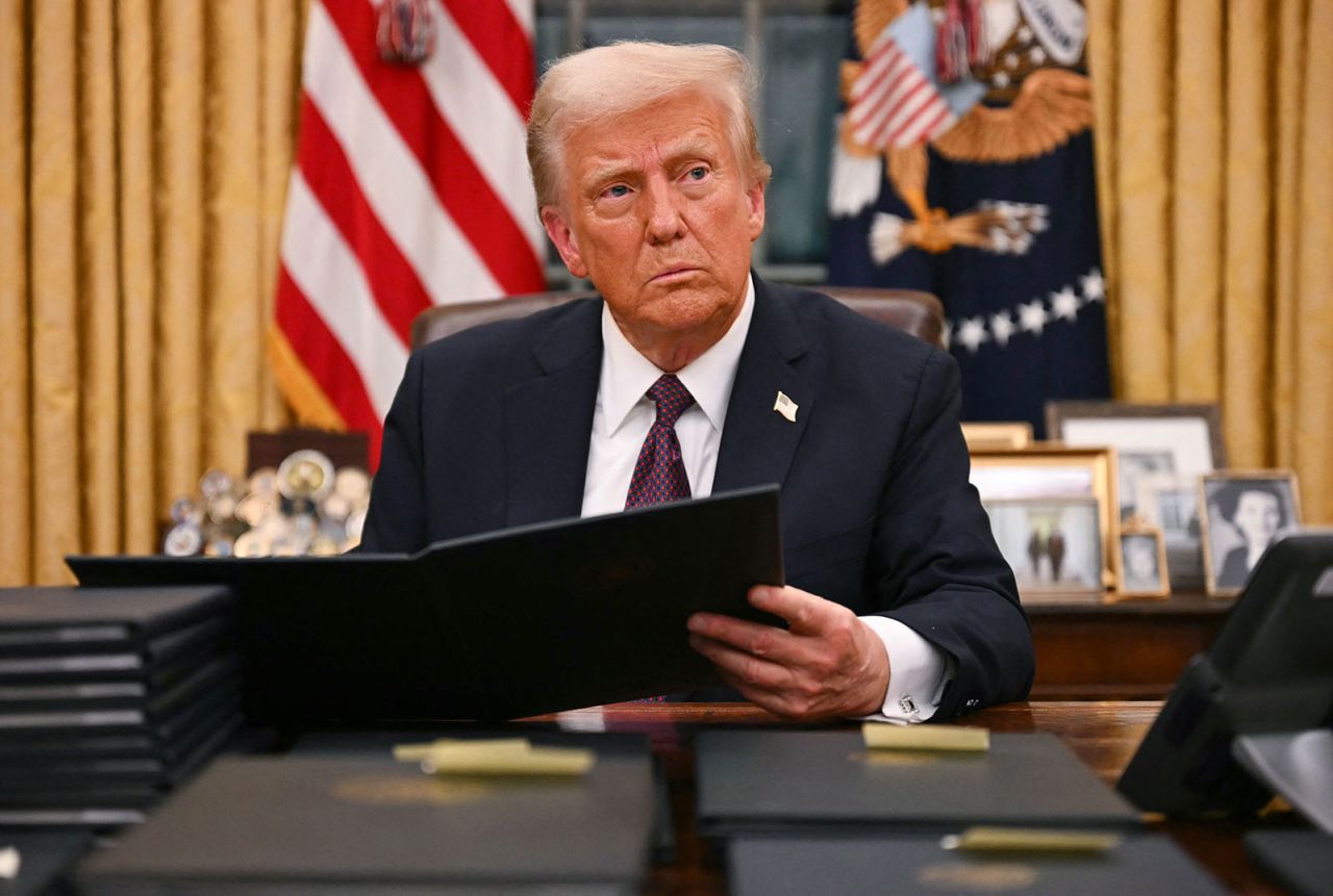 President Donald Trump signs an executive order in the Oval Office of the White House in Washington, DC, on Monday.