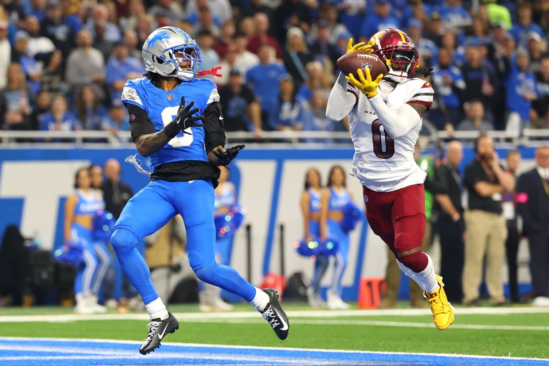 Mike Sainristil #0 of the Washington Commanders intercepts a pass intended for Jameson Williams #9 of the Detroit Lions in the second quarter of the NFC Divisional Playoff.