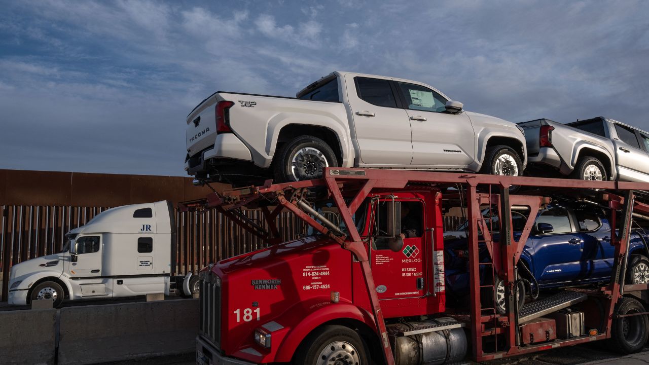 A car carrier trailer waits in line next to the border wall before crossing to the United States at Otay commercial port in Tijuana, Baja California state, Mexico, on January 22, 2025. US President Donald Trump has threatened to slap a 25-percent tariff on Mexican goods on February 1, a move that analysts say would deal a heavy blow to Latin America's second-largest economy. (Photo by Guillermo Arias / AFP) (Photo by GUILLERMO ARIAS/AFP via Getty Images)