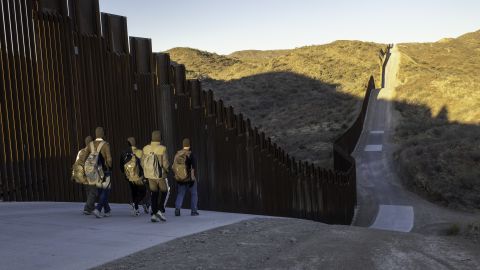 Inmigrantes de la India caminan junto a la valla fronteriza entre Estados Unidos y México, construida por Trump, tras cruzar a Arizona el 19 de enero de 2025 cerca de Sasabe, Arizona.