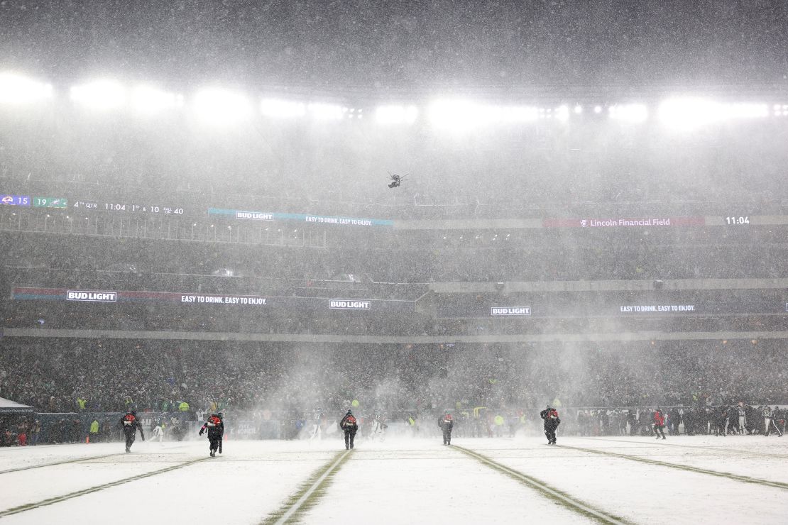 Grounds crew workers clear snow off of the field during the game between the Philadelphia Eagles and the Los Angeles Rams in the NFC Divisional Playoff at Lincoln Financial Field.