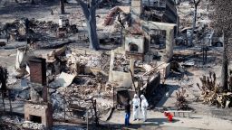 An aerial view of a couple meeting with a FEMA representative while searching through the remains of their home which burned in the Eaton Fire on January 19, 2025 in Altadena, California.