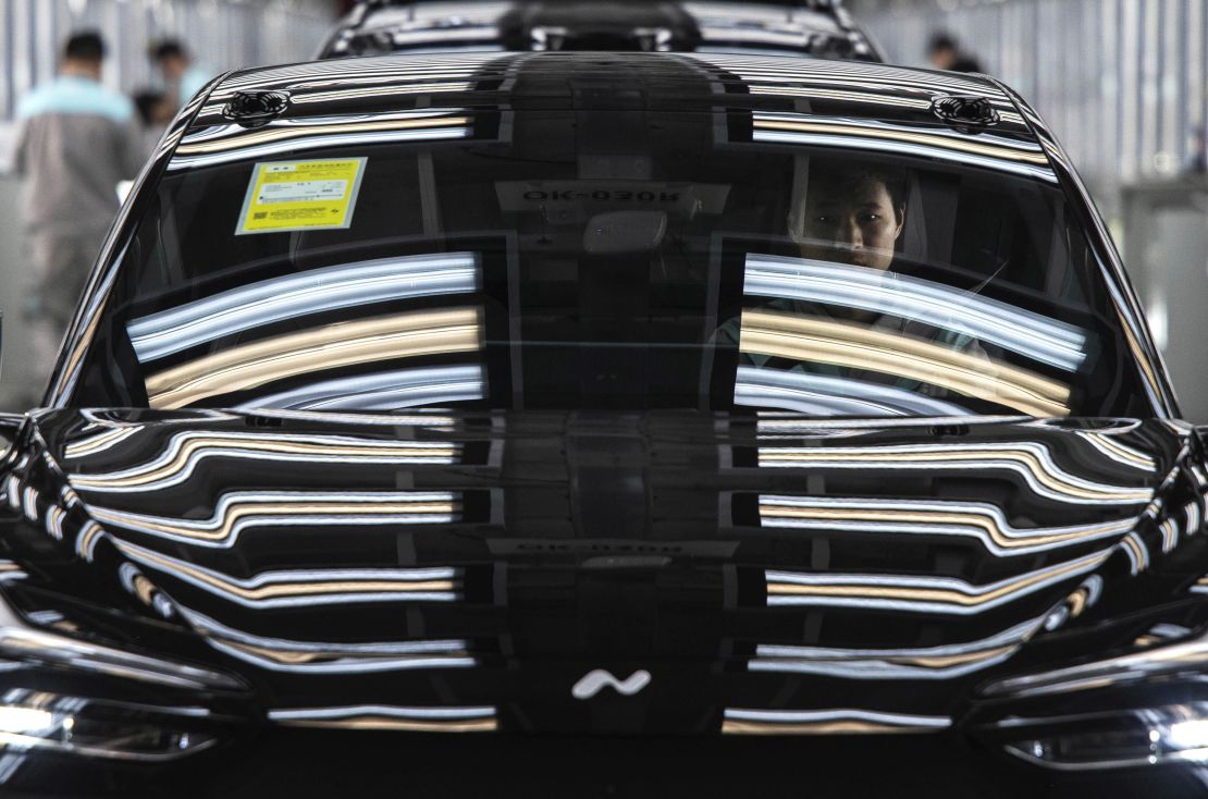 A worker from Chinese electric vehicle company NIO sits in a car during its final inspection at the end of the automated production line at the company's manufacturing hub in Hefei, China, on January 17, 2025.