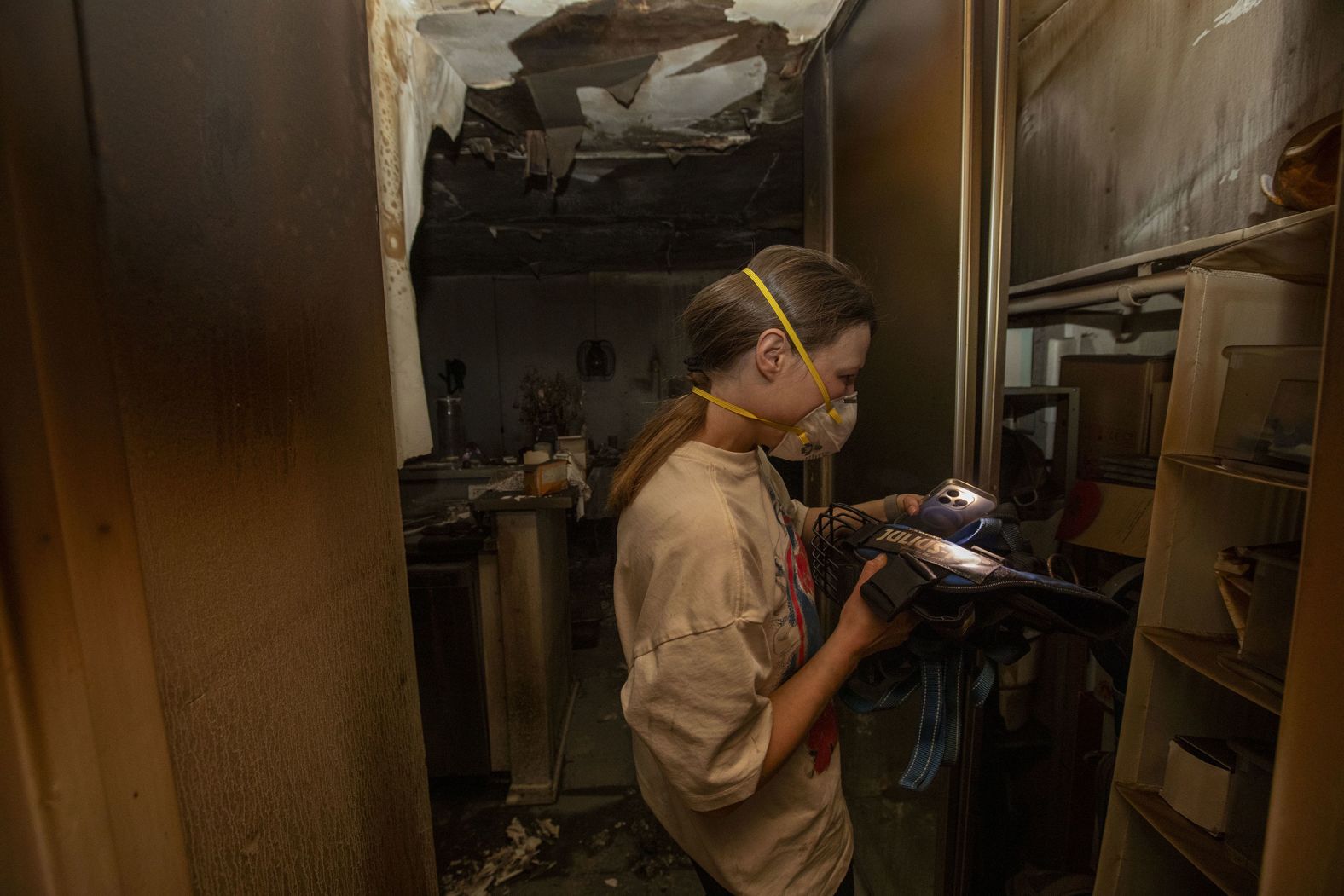 A woman goes through the remains of her apartment, which was destroyed by the Palisades Fire.