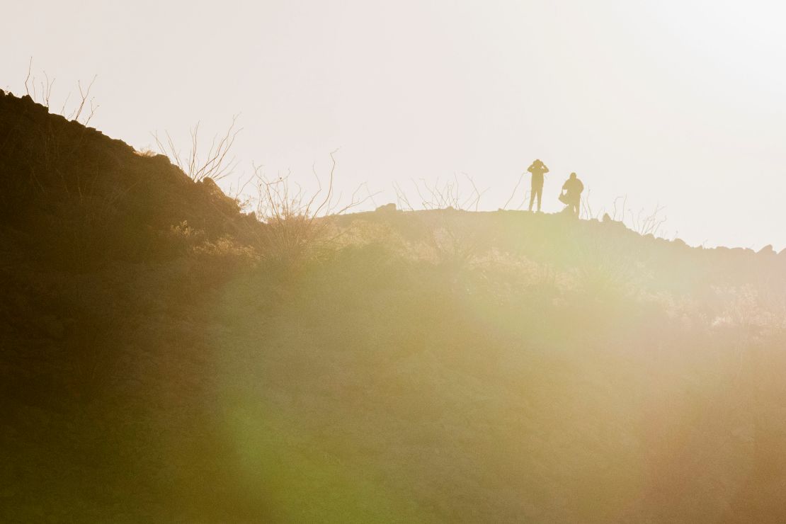 A cartel scout looks through binoculars on the US-Mexico border in Sunland Park, New Mexico, on January 24.