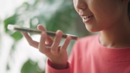 Asian young woman asking ai voice on smartphone at home.