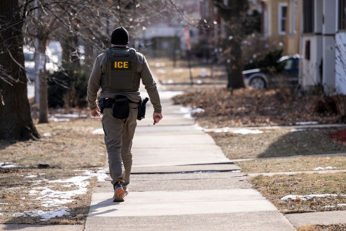 An Immigration and Customs Enforcement agent walks down a street during a January multi-agency targeted enforcement operation in Chicago.