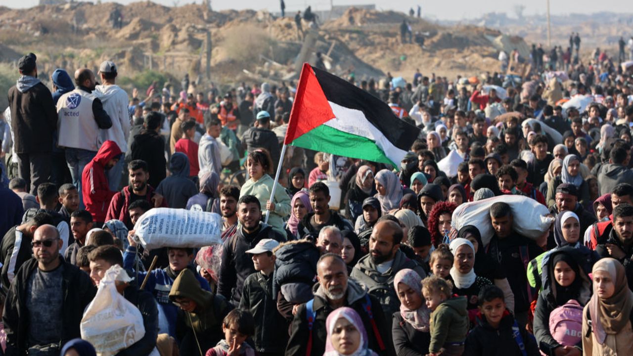 People walk along Gaza's coastal al-Rashid Street to cross the Netzarim corridor from the southern Gaza Strip into the north on January 27, 2025. Displaced Palestinians began returning to northern Gaza on January 27, an official at the territory's Hamas-run Interior Ministry told AFP, after a breakthrough in negotiations between Hamas and Israel. (Photo by Omar AL-QATTAA / AFP) (Photo by OMAR AL-QATTAA/AFP via Getty Images)