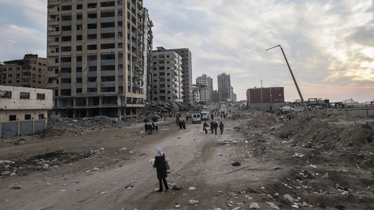 Displaced Palestinians pass destroyed buildings as they return to the north from the southern Gaza Strip via the Al Rachid road, during the ceasefire, in Gaza City, Gaza, on Tuesday, Jan. 28, 2025. Tens of thousands of Palestinians are travelling back to the devastated neighborhoods of northern Gaza after being displaced during the Israel-Hamas war, as a fragile 42-day ceasefire moves into a second week. Photographer: Ahmad Salem/Bloomberg via Getty Images