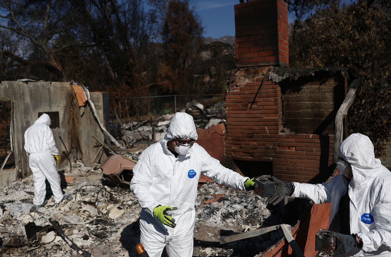 Nick Sonnenburg, center, and his parents search through the remains of his apartment in Altadena on Saturday, January 25.