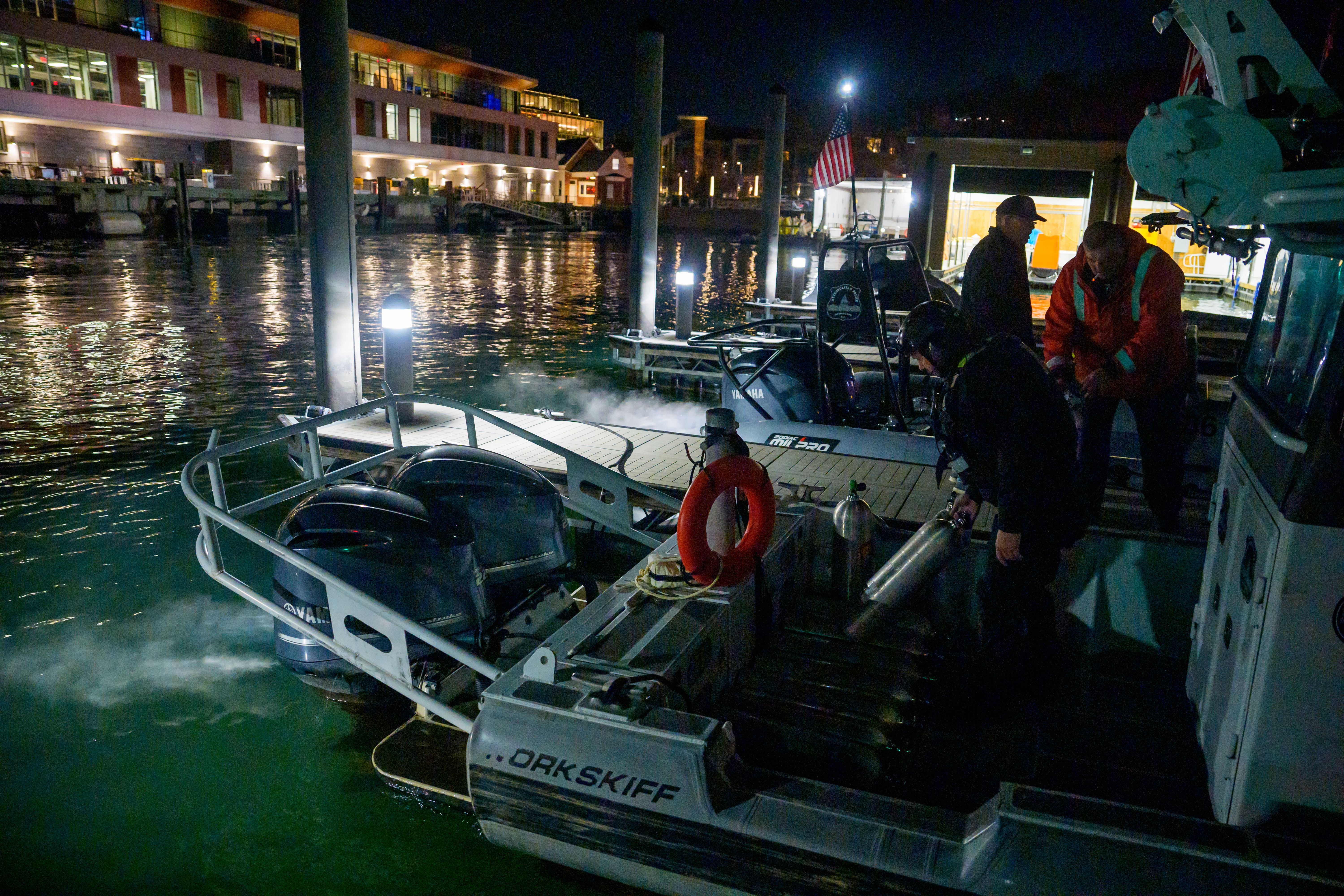 An emergency response team loads diving equipment on a boat Thursday.