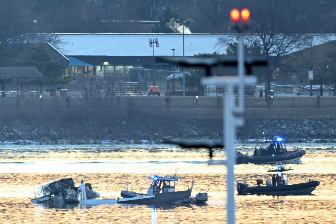 Part of the wreckage from the plane and helicopter collision is seen as rescue boats search the Potomac River.