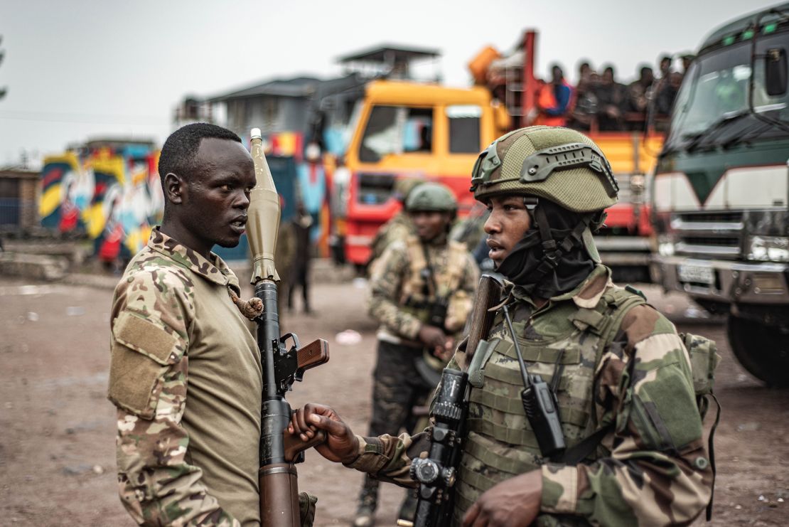 M23 fighters stand nearby as an estimated 2400 Congolese (FARDC) soldiers surrender en masse to the rebel group at the Stade de l'Unite on January 30, 2025 in Goma, DRC.