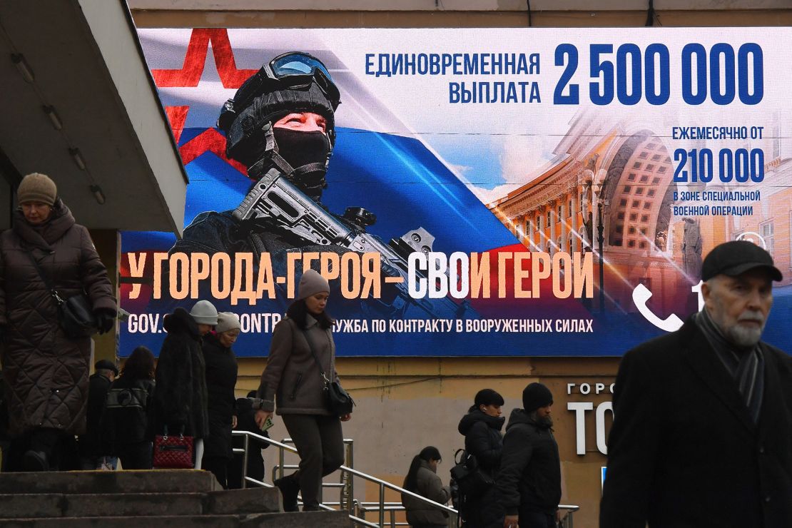 У січні пішоходи проходять повз рекламну рекламну контрактну службу в Санкт -Петербурзі.