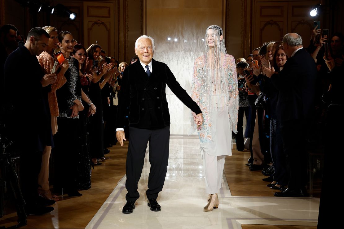 Modeontwerper Giorgio Armani vierde zijn grote mijlpaal door een buiging te nemen met een model aan het einde van de show.